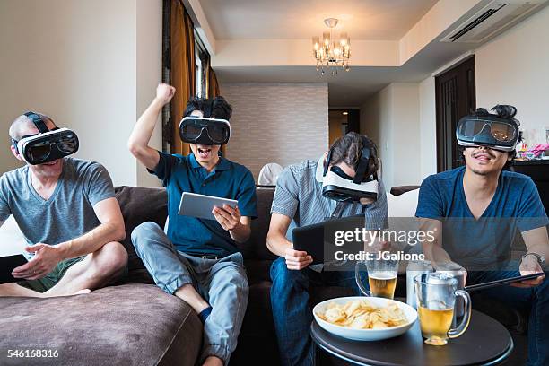 group of friends playing games using virtual reality headsets - game four stockfoto's en -beelden