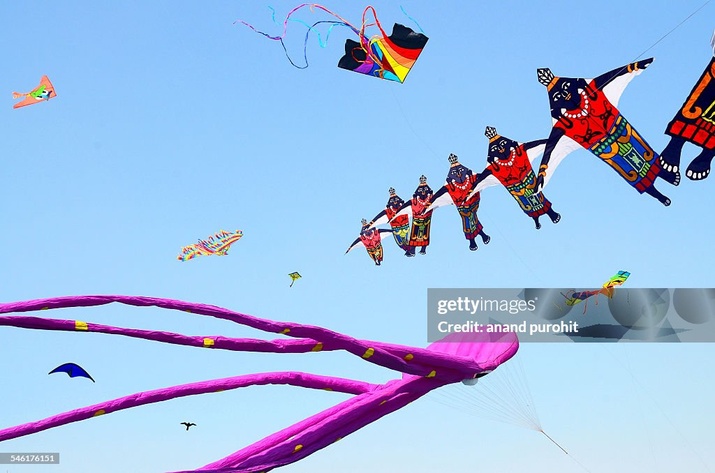 Colourful kites flying in clear blue sky, India