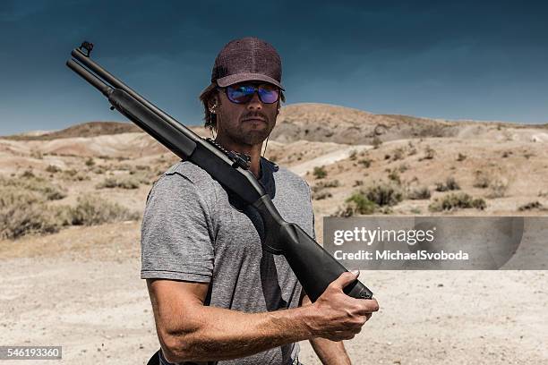 hombre disparando una escopeta calibre 12 - clay shooting fotografías e imágenes de stock