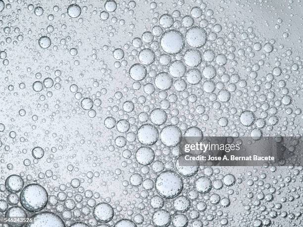 full frame oil bubble floating on water on a white background - exploding glass stock pictures, royalty-free photos & images