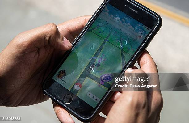 Sameer Uddin plays Pokemon Go on his smartphone outside of Nintendo's flagship store, July 11, 2016 in New York City. The success of Nintendo's new...