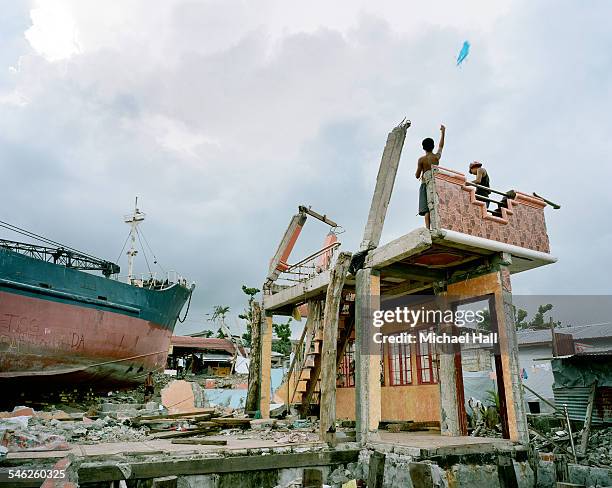 boys flying kite from remains of ravaged building - hurricane supplies stock pictures, royalty-free photos & images