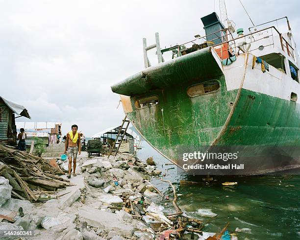 man walking near grounded ship post storm surge - coastal deprivation stock pictures, royalty-free photos & images