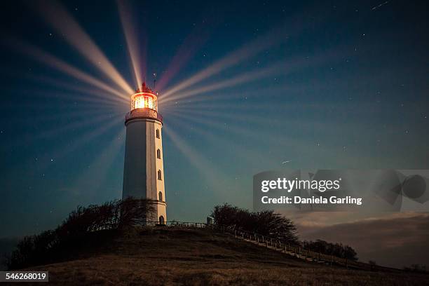 lighthouse on a hill shining at night - hiddensee stock-fotos und bilder