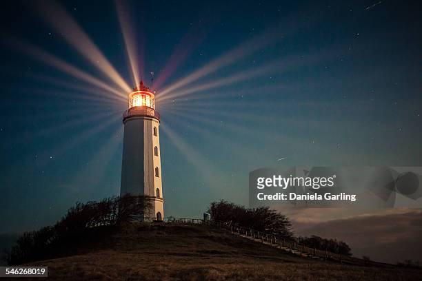 lighthouse on a hill shining at night - hiddensee photos et images de collection