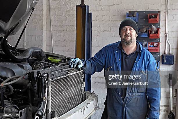 portrait of a mechanic shoot in his garage - mechanic portrait stock-fotos und bilder