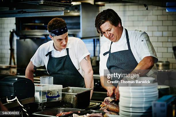 executive chef demonstrating how to process duck - chef leader - fotografias e filmes do acervo