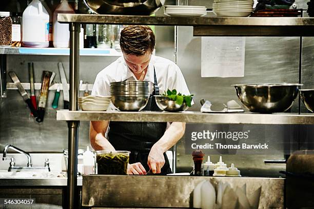 sous chef chopping ingredients for dinner service - commonwealth of independent states stockfoto's en -beelden