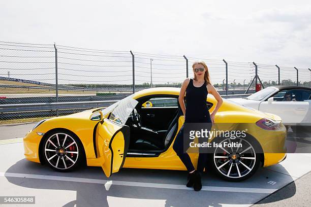 German actress Julia Dietze in front of a Porsche 911 Carrera S, wearing a total look from the Porsche Design Woman SS17 Collection at the 'Porsche...