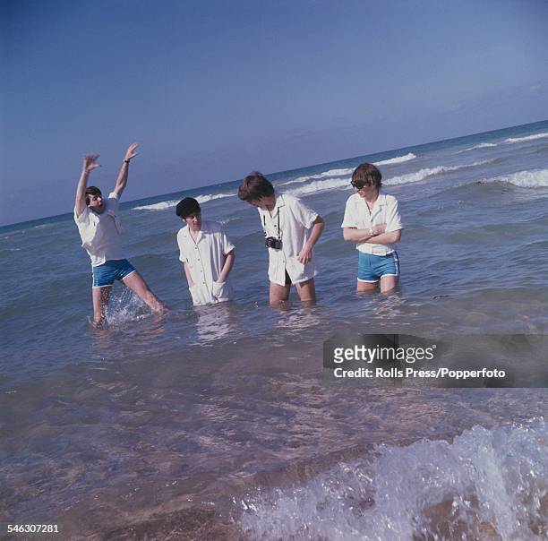 English pop group The Beatles joke and paddle in the sea at Miami Beach in Florida during a break from recording a performance for the Ed Sullivan...