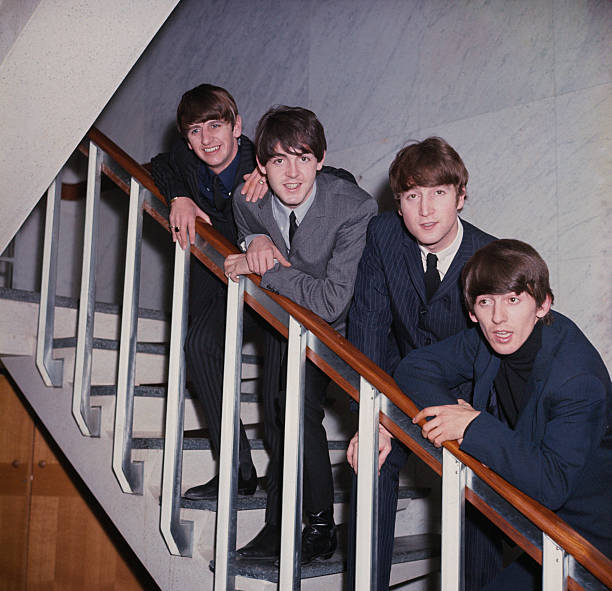 English pop group The Beatles posed on a staircase in 1964. From left to right: Ringo Starr, Paul McCartney, John Lennon and George Harrison.