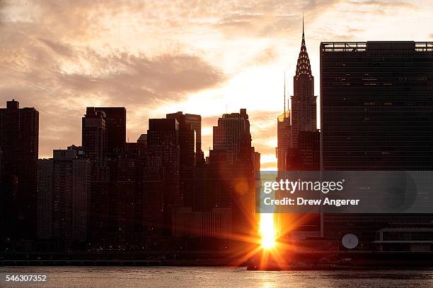 View of the 'Manhattanhenge' sunset from Hunters Point South Park, July 11, 2016 in the Queens borough of New York City. 'Manhattanhenge' is created...