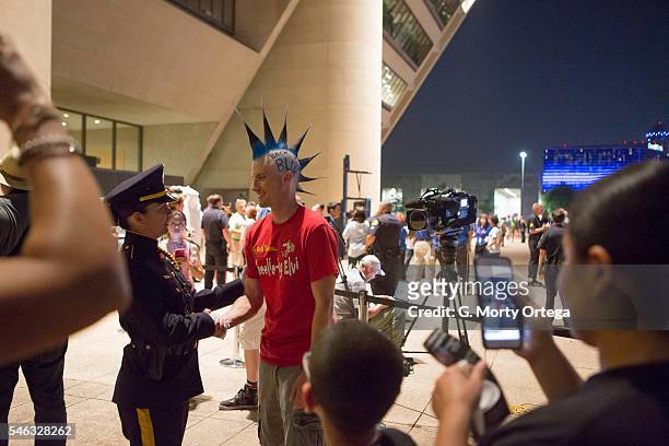 Brian Schober sports a blue mohawk as he thanks Dallas Police Detective Margarita Argumedo at the Dallas Strong Candelight Vigil on July 11, 2016 in...