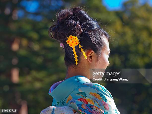 Tokyo, Japan Young Japanese woman in kimono and having traditional hair ornaments is posing for cameras in Meiji Jingu on Japanese national holiday...