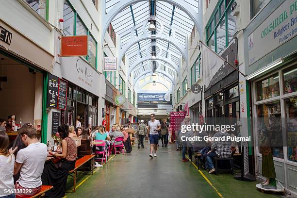 Brixton Village Market in London during a sunny day. People is eating in the corridor. Picture taken in June 2013