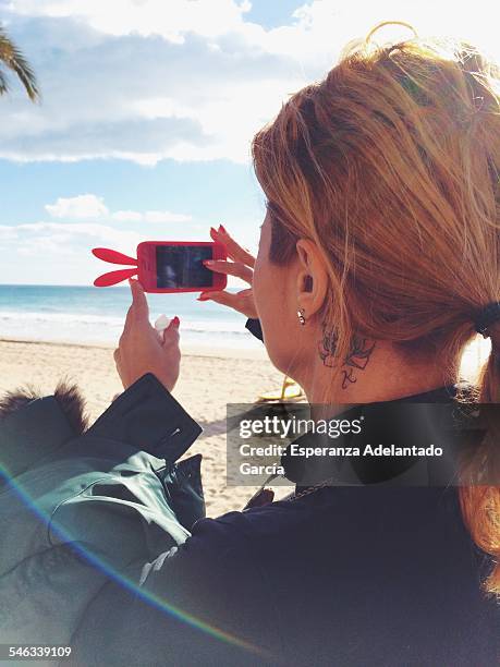 Woman take a picture with smartphone in Benidorm, Spain