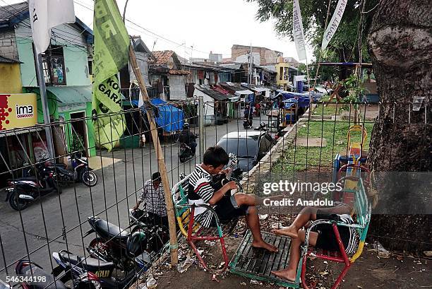 Two boy play guitar at the slum area in Jakarta, Indonesia, on July 11, 2016. Indonesia is the most populous country in Southeast Asia, with a...