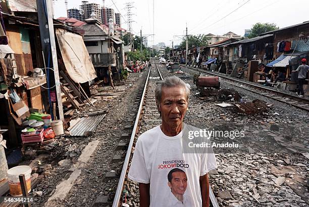 Indonesian residents stand near the railway tracks at the Slum area in Jakarta, Indonesia, on July 11, 2016. Indonesia is the most populous country...