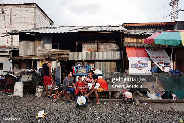 Indonesian residents stand near the railway tracks at the Slum area in Jakarta, Indonesia, on July 11, 2016. Indonesia is the most populous country...