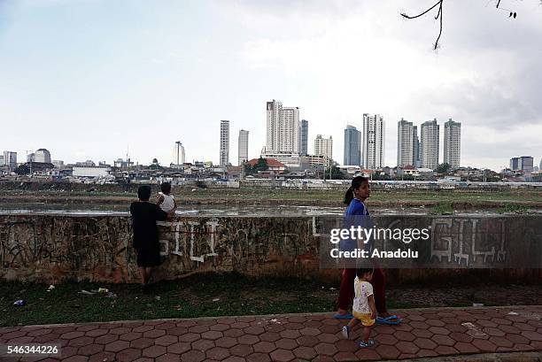Indonesian residents stand near the railroad at the slum area in Jakarta, Indonesia, on July 11, 2016. Indonesia is the most populous country in...