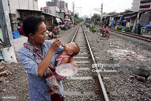 Woman feeds her baby near the railway tracks at the Slum area in Jakarta, Indonesia, on July 11, 2016. Indonesia is the most populous country in...