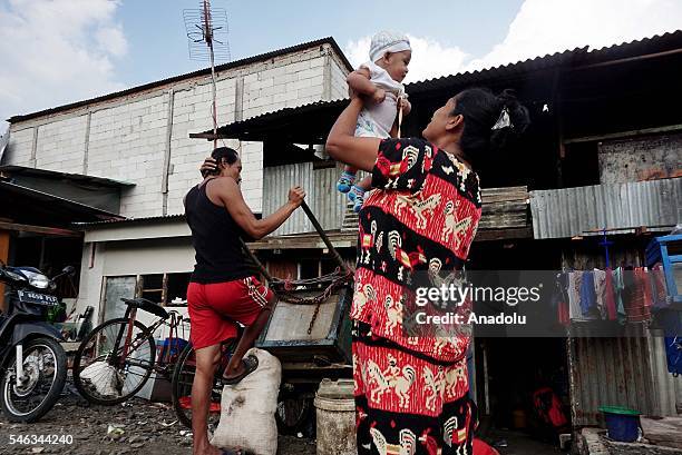 Indonesian residents stand near the railway tracks at the slum area in Jakarta, Indonesia, on July 11, 2016. Indonesia is the most populous country...