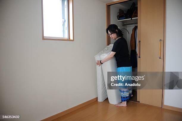 Minimalist Saeko Kubishiki gets out a futon from a small laundry room in her appartment in Fujisawa, Kanagawa Prefecture in the southern of Tokyo,...