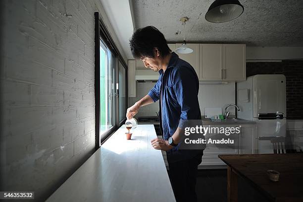 Minimalist Naoki Numahata pours coffee in a coffee cup in his kitchen at his apartment in Tokyo, Japan, on July 02, 2016. Naoki Numahata a freelance...