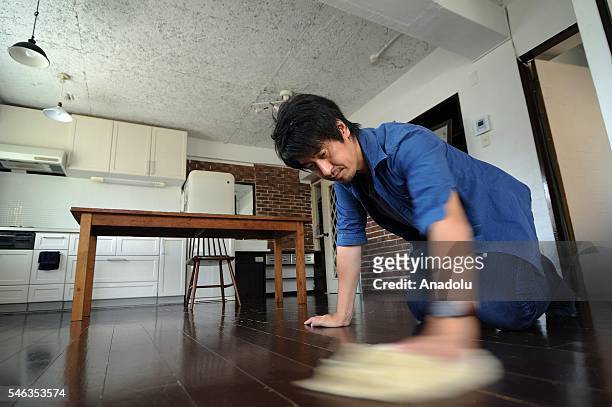 Minimalist Naoki Numahata cleans the floor of his home in Tokyo, Japan, on July 02, 2016. Naoki Numahata a freelance writer who lives with his wife...