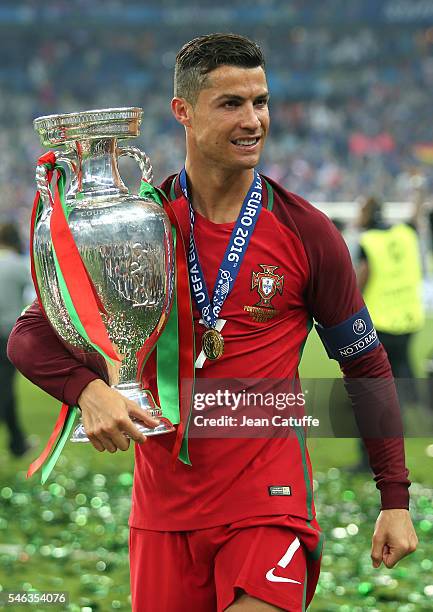 Cristiano Ronaldo of Portugal holds the trophy following the UEFA Euro 2016 final between Portugal and France at Stade de France on July 10, 2016 in...