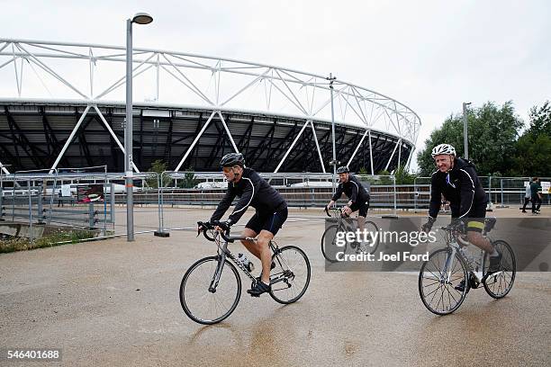 Referees Martin Atkinson, Mike Riley and Jon Moss cycle past the Olympic Stadium during the Premier League Referees Charity Bike Ride on July 12,...