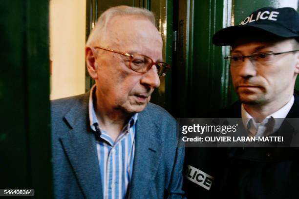 French satirical weekly Canard Enchaine's chief editor Claude Angeli leaves his office passing next to a policeman, 11 May 2007 in Paris, during a...