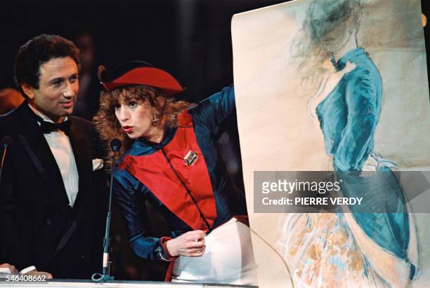 French actress Anemone comments her portrait after being awarded 12 March 1988 in Paris a Cesar statue by French TV presenter Michel Drucker 12 March...
