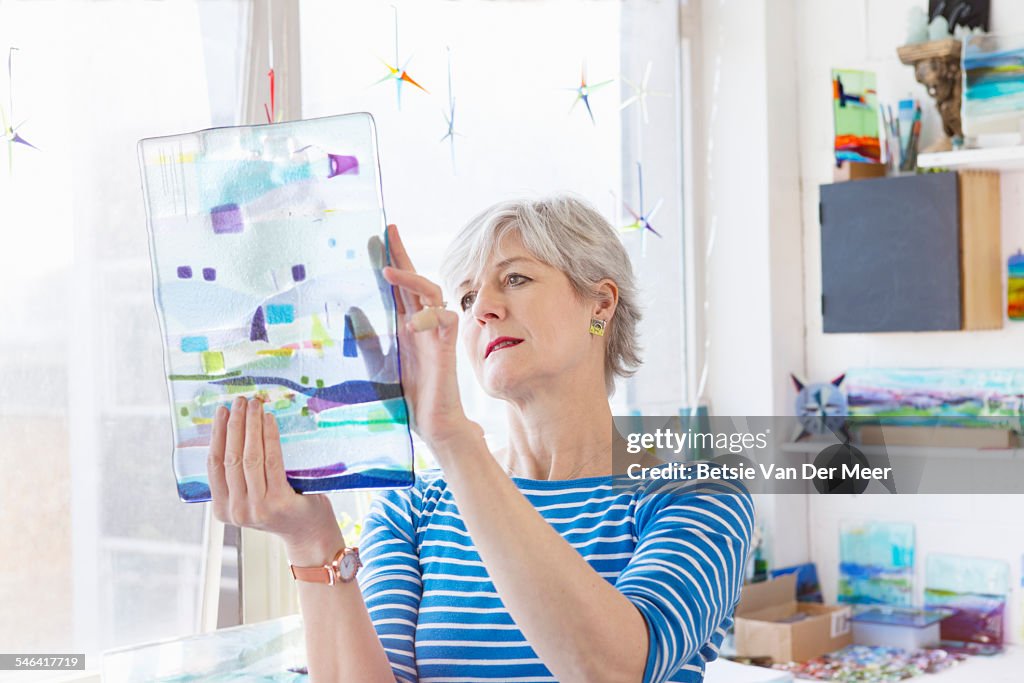 Glass designer checks glass design in studio.