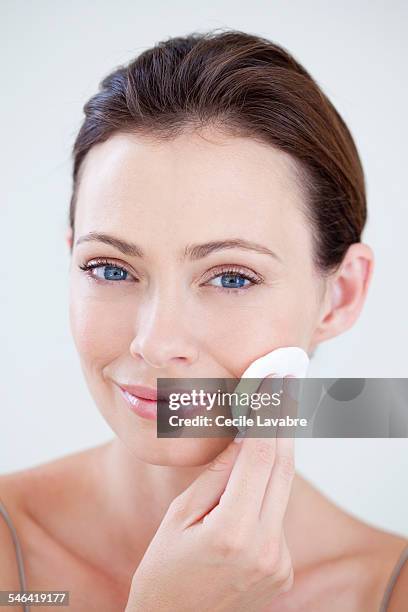 woman cleaning face with cotton wool - silky brown hair stock pictures, royalty-free photos & images