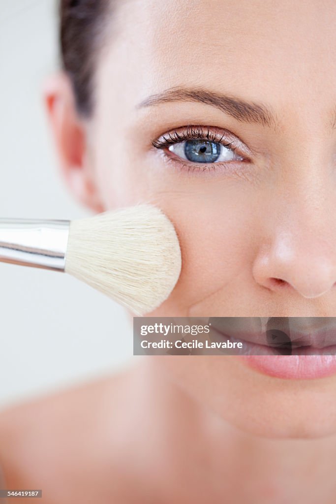 Woman applying make-up with brush