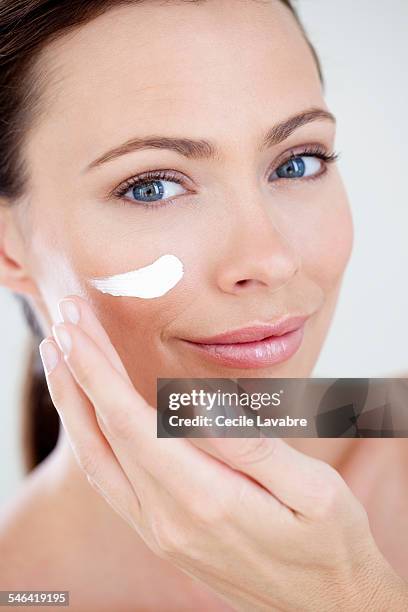 woman appying face cream - 乳液 ストックフォトと画像