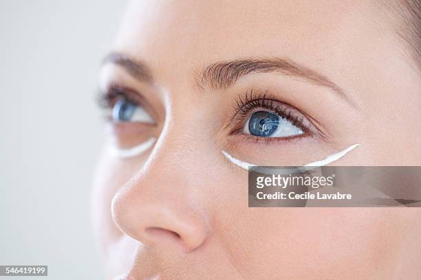 woman with eye cream - figura mujer fotografías e imágenes de stock