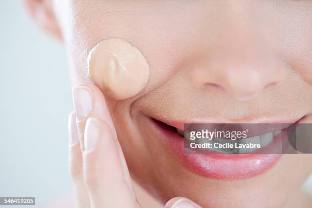 woman applying foundation, close up - woman applying makeup stock-fotos und bilder