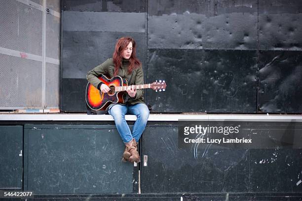 young woman playing music on outdoors stage - busker 個照片及圖片檔