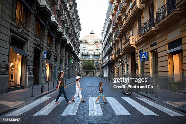 family crossing a pedestrian crossing - strisce pedonali foto e immagini stock