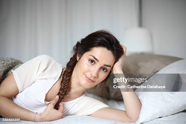 a young woman laying on her bed - fishtail braid stock pictures, royalty-free photos & images