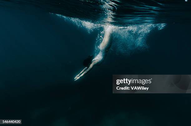 diving down into darkness in tahoe - woman free diving stock pictures, royalty-free photos & images