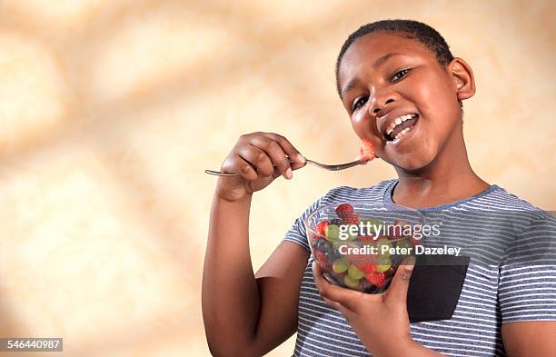 overweight boy eating fruit - chubby boy fotografías e imágenes de stock