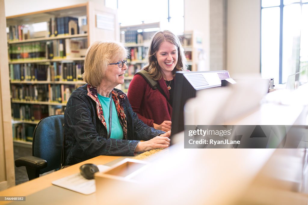 Femme âgée sur ordinateur de bibliothèque