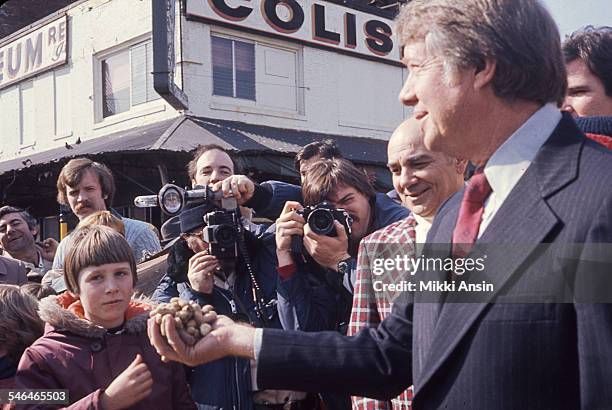 American politician and US Presidential candidate Jimmy Carter holds a handful of peanuts during a campaign event, Boston, Massachusetts, 1976.