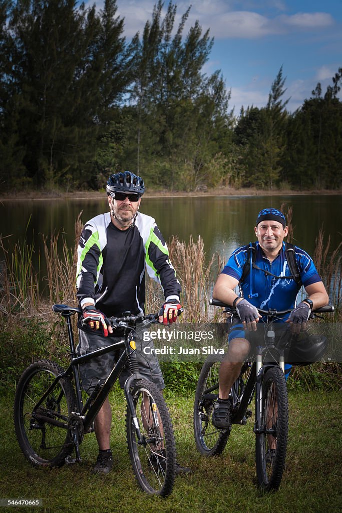 Portrait of two men on muntain bike by lake