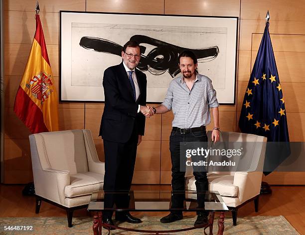 Spanish Prime Minister Mariano Rajoy and Leader of left wing party Unidos Podemos Pablo Iglesias shake hands during their meeting at Spanish...