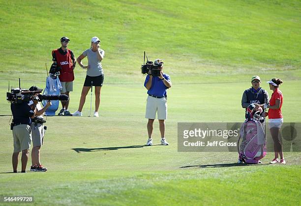 Brittany Lang and her caddie discuss her third shot after being informed by a USGA official that Anna Nordqvist of Sweden was assessed a two stroke...