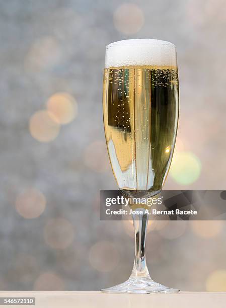 filling a glass of champagne on a table iluminanada for the light of the sun - champagner gläser mit flasche unscharfer hintergrund stock-fotos und bilder